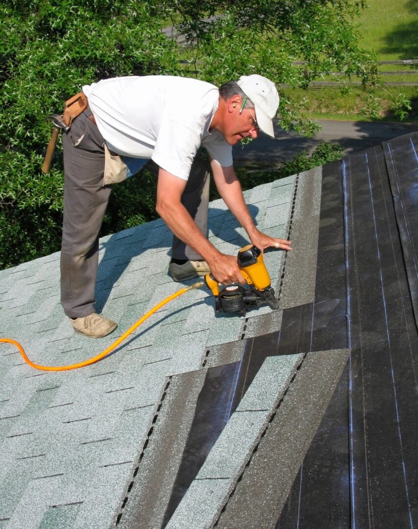 A man using a drill on a roof.